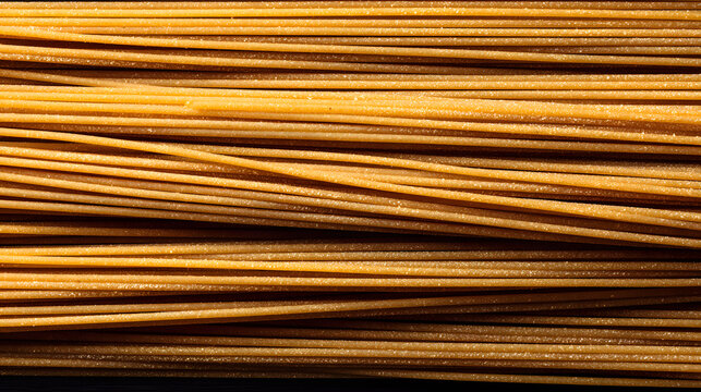 Golden uncooked pasta arranged closely together exhibits its texture and color under bright lighting in a kitchen