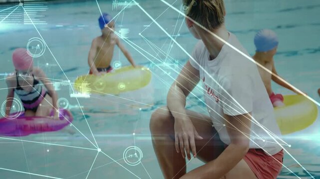 Lifeguard crouching pool edge reaching for orange buoy, tracking kids in rings under HUD for safety