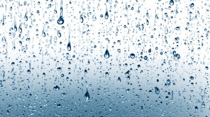 Raindrops are flowing down the wet surface of a window glass, creating patterns against a white background with clear visibility