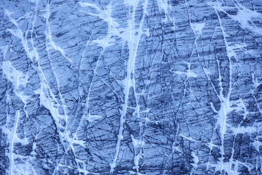 View of cracked blue stone, its pale veins tracing paths across the surface in Chiesa in Valmalenco, Lombardy, Italy, Chiesa in Valmalenco, Lombardy, Italy.