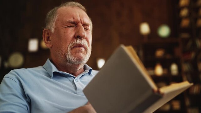 Sad elderly man suffering sharp chest pain while reading book, heart attack risk