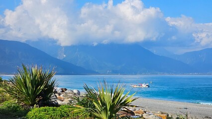 Small working fishing boats and utility vessels anchored along Hualien coastline, calm blue waters and traditional maritime livelihood scene under clear coastal sky in eastern Taiwan © Bambinosu