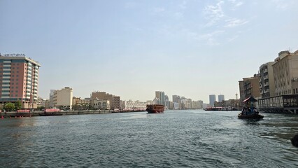 Obraz premium Traditional Abra Boats Crossing Dubai Creek with City Skyline