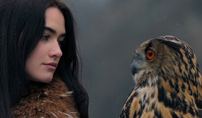 Profile portrait of woman and eagle owl looking at each other © Stanislav