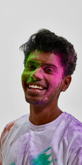 Fototapeta premium Happy young man with colored powder on face portrait. Concept of Holi celebration mood, authentic cultural tradition, festive lifestyle moment and social media branding visual.