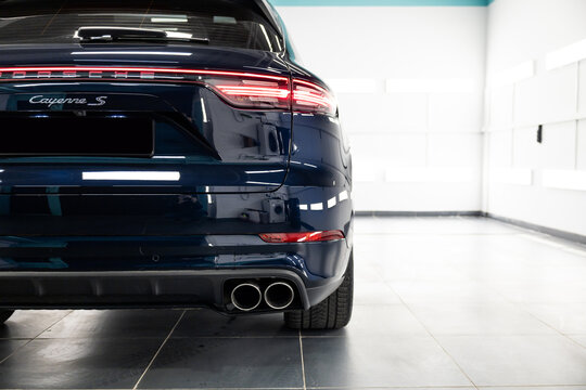Dark blue Porsche Cayenne S on a white background in a detailing studio. Premium luxury SUV with sporty design and glossy finish, captured in clean professional automotive photography.