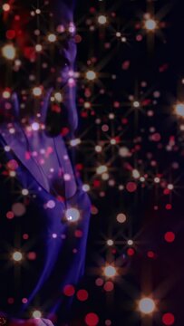 Vertical video: Woman drummer initiating beat, hitting drum and playing music under sparkly bokeh