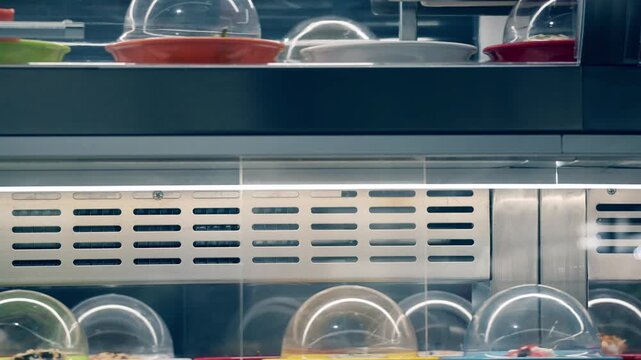 Sushi plates move on a conveyor belt at a sushi restaurant while customers wait for their meal