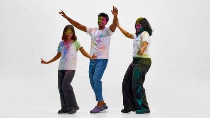 Fototapeta premium Friends expressing cultural identity through Holi festival dance. Concept of diversity in modern society, preservation of tradition and joyful community celebration across cultures.