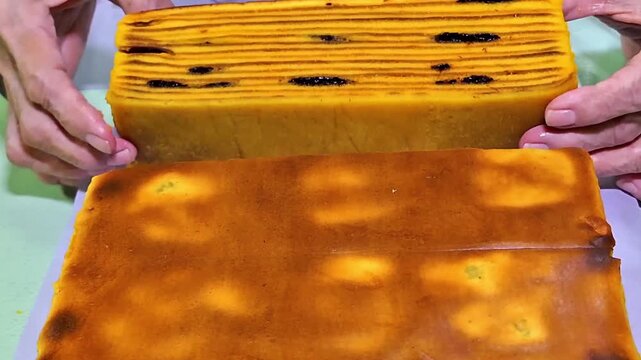 Freshly baked prune Lapis Legit (thousand-layer cake) in close-up, revealing its rich layered texture.