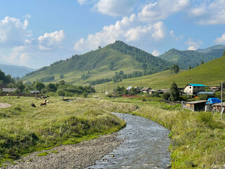 Mountain landscape. A shallow river flows in a mountain village. Altai, Russia