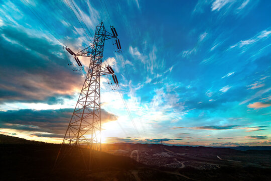 Concepto de energ&iacute;a y electricidad.Torre de alta tensi&oacute;n al atardecer. L&iacute;neas el&eacute;ctricas y distribuci&oacute;n energ&eacute;tica en paisaje natural.