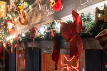 Festive Christmas garland with sparkling red bows and glowing lights, creating a cheerful holiday atmosphere on a building facade at night