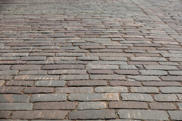 Naklejka premium A classic cobblestone or stone paving stone. This pavement is used on a medieval historic street or pedestrian area in the old town