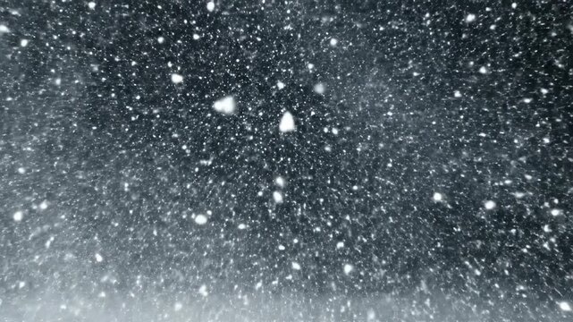 Intense winter storm simulation. Fast moving white snow particles on black background for overlay effects and weather projects.