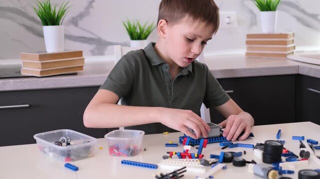 boy builds a toy robot car using his imagination. Robotics, children's technology, robot construction kit, educational toy.
