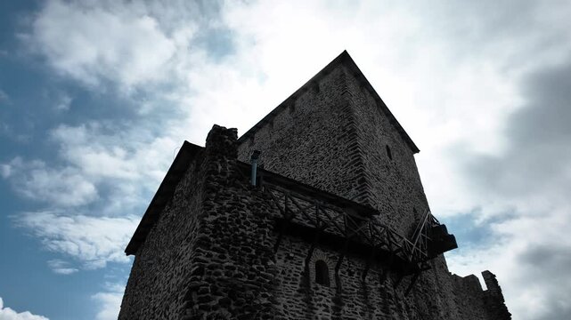 Vrsac Fortress stone tower and walls under blue sky with clouds in Serbia. Medieval stronghold landmark standing on the hill above the town