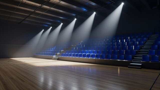 An empty indoor basketball court with polished wooden floor and blue seats under spotlights.