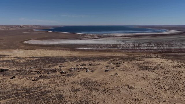 Aerial view of a remote ghost town and salty Aral sea in a desert landscape, Kazakhstan