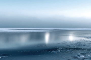 Obraz premium This serene landscape image presents a frost-covered lake with a misty horizon, creating a dreamy atmosphere that evokes feelings of tranquility and contemplation.
