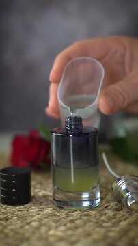 Vertical video of adding ethanol alcohol to essential oils in black perfume bottle. Creating natural homemade perfume with luxury and botanical fragrance concept.