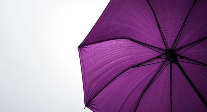 Purple umbrella fully extended against a crisp white backdrop highlighting fabric texture