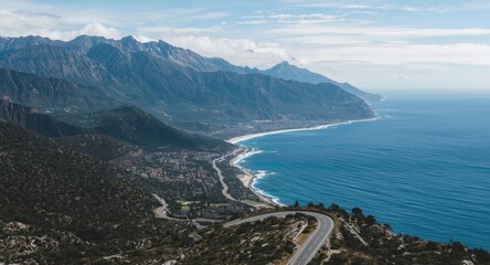 Winding ocean road bordered by majestic mountain ranges