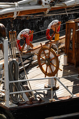 Vintage wooden ship steering wheel on the deck of a sailing vessel © 9parusnikov