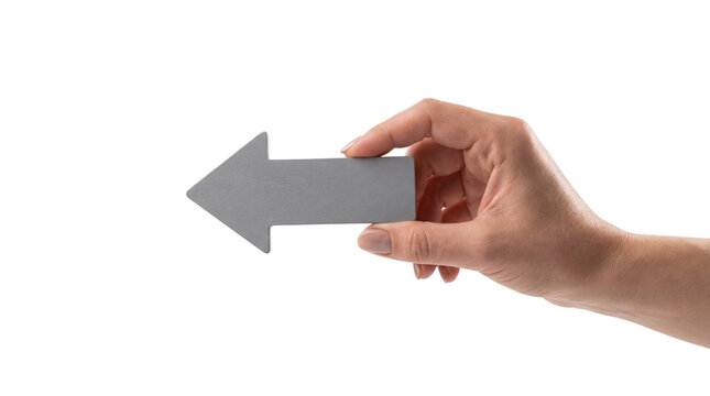 Hand holding gray arrow pointing left on white background