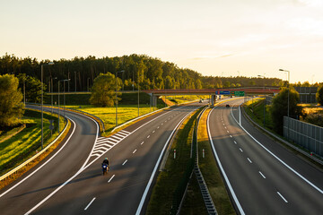 The highway near Brzesko at sunset with motorcyclist on the road | Autostrada w pobliżu Brzeska z motocyklistą na drodze, o zachodzie słońca