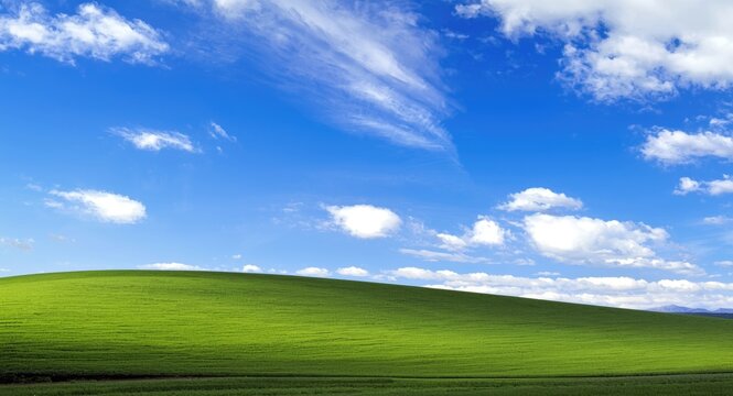 Wallpaper with blue sky clouds creating scenic view over rolling grassy hill
