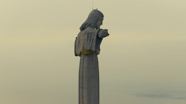 Drone view of the Christ the King monument in Almada, Portugal, with the 25 de Abril Bridge spanning the Tagus River and Lisbon visible in the background.

