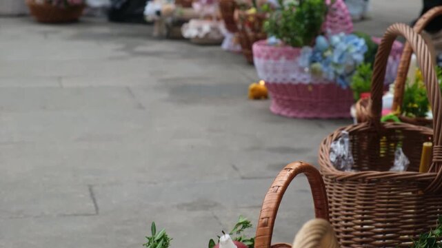 Festive wicker baskets with flowers and candle on pavement