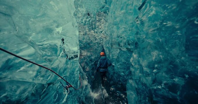 Explorer inside a blue ice cave in Iceland