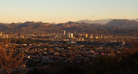 Fototapeta premium Metropolitan area glowing with afternoon sun and majestic hills behind