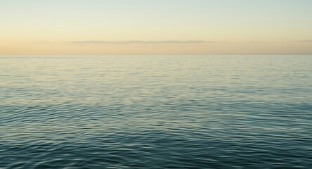 Obraz premium softly lit early morning sea with gentle ripples and clear horizon