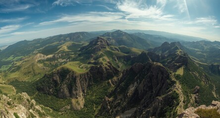 Fototapeta premium Panoramic birdseye image of a rugged mountain range enclosed by natural greenery