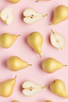 Golden Asian pears scattered on a soft pink surface create a vibrant and cheerful display of nature's sweetness and beauty