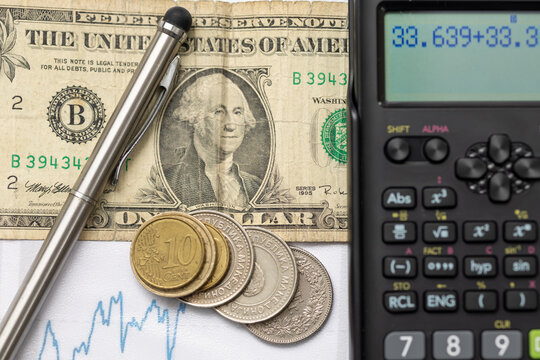 top view of us dollar banknote with macedonian denar coins, stylus pen, and scientific calculator on blue line graph background for financial analysis concept