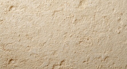 Obraz premium coarse beige plaster surface showing natural grain and gentle shadow texture