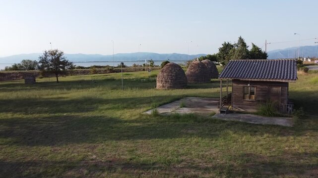 Drone aerial view of the Sarakatsani Settlement in Porto Lagos, Xanthi, showcasing traditional huts and pastoral architecture representing the nomadic heritage of Thrace.