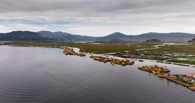 Traditional totora reed islands and homes of the Uru people on Lake Titicaca in Puno, Peru. Aerial drone ascending, copy space