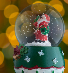 Christmas lights glowing behind a snow globe with Santa