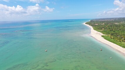Fototapeta premium Wonderful view of white sand beach with turquoise waters and coral reefs in Milagres route near Maceio city, Alagoas State, Brazil 