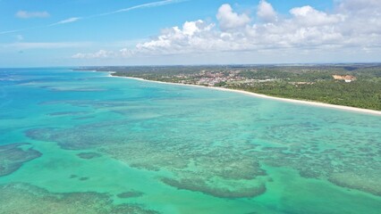 Obraz premium Wonderful view of white sand beach with turquoise waters and coral reefs in Milagres route near Maceio city, Alagoas State, Brazil 