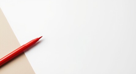 Red colored marker placed next to a blank white paper background with copy space