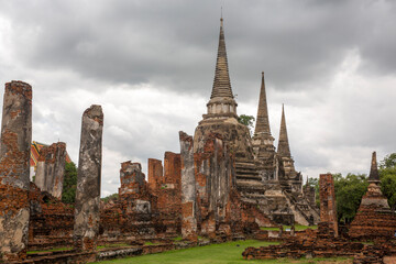 Obraz premium Panorama of the ancient ruins of Wat Phra Si Sanphet in Ayutthaya, Thailand. The composition emphasizes the scale of the former royal temple and the historic nature of the archaeological site.