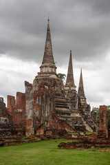 Obraz premium Panorama of the ancient ruins of Wat Phra Si Sanphet in Ayutthaya, Thailand. The composition emphasizes the scale of the former royal temple and the historic nature of the archaeological site.