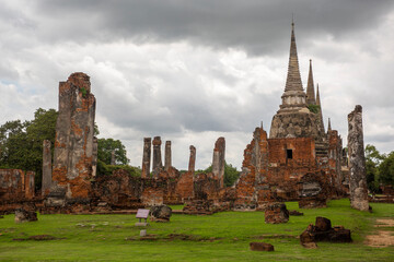 Obraz premium Panorama of the ancient ruins of Wat Phra Si Sanphet in Ayutthaya, Thailand. The composition emphasizes the scale of the former royal temple and the historic nature of the archaeological site.