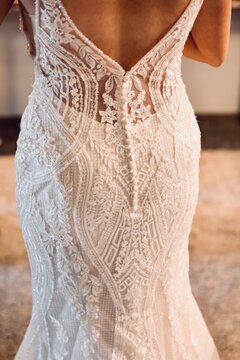 Rear view close-up of a bride wearing an elegant backless wedding dress